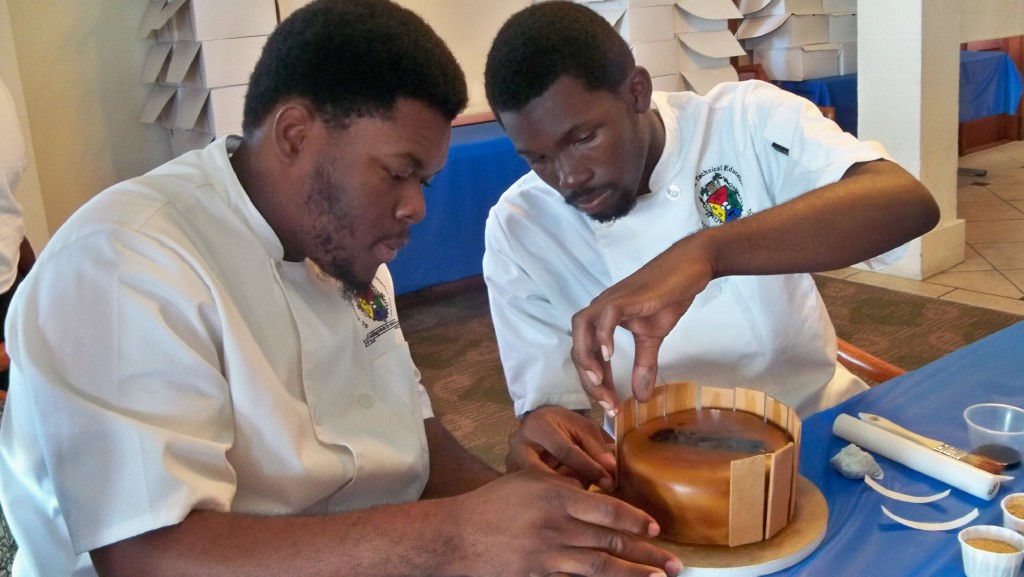 Local culinary students Romano Thomas, left, and Deshaun Quinland decorate a cake.