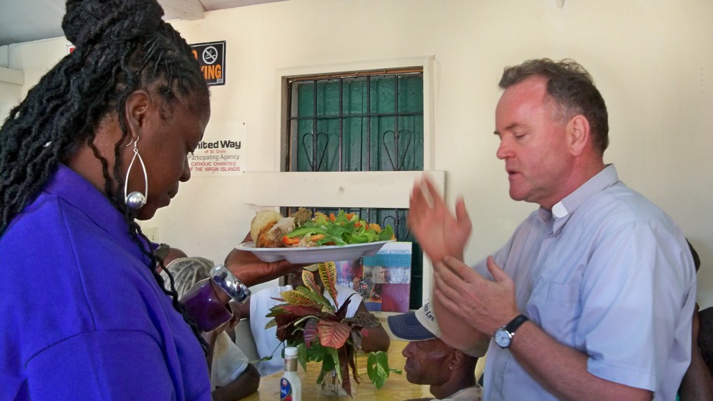 Brenda Charles and the Rev. Andrew Szorc bless the food at Catholic Charities' 2010 Thansgiving luncheon.