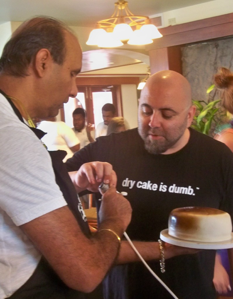 Gary Udhwani, left, and Chef Duff airbrush a cake.