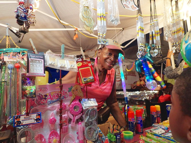 Vendor Jennifer Parris talks to customers during Independence Day street fair in Frederiksted.