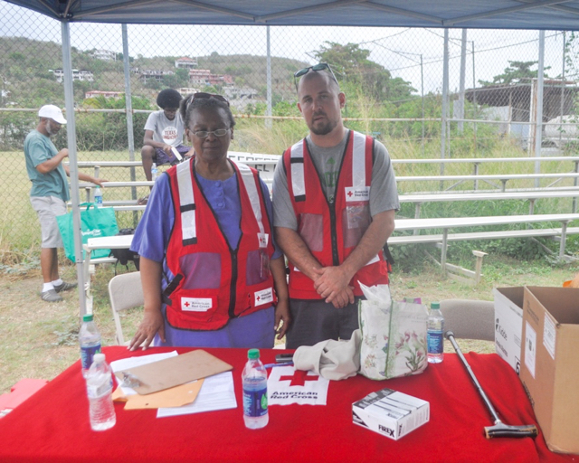 Disaster Program specialist Robert Sofaly and volunteer Carol Liles man the Home Fire Preparedness tent Saturday in Smith Bay.