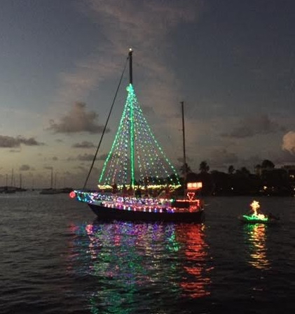 One of the brightly lit boats from the parade makes its way through Christiansted harbor.