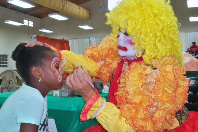ViVi the Clown paints the face of Nilana Browne.