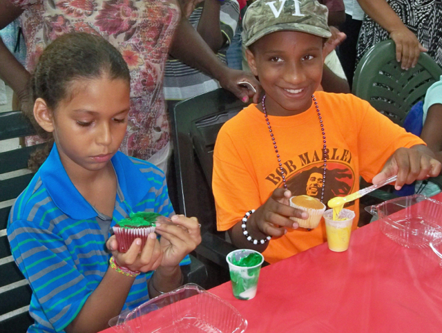 Lazaro Ransom and Khannye Williams, both 10 years old, decorate cupcakes.