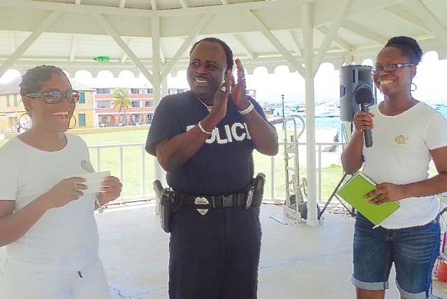 Resa O&rsquo;Reilly, left, and Erica Parson of Project Promise present a check to Officer Charles Nibbs Saturday for cancer patient Demarcus Navarro.  (Susan Ellis photo)