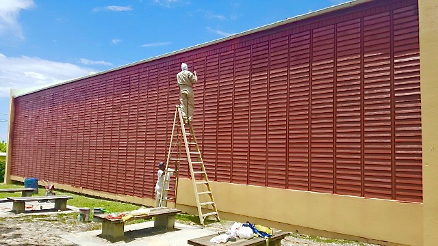 Painters put a coat on the shutters at Lew Muckle Elementary School. (Photo by the V.I. Department of Education)
