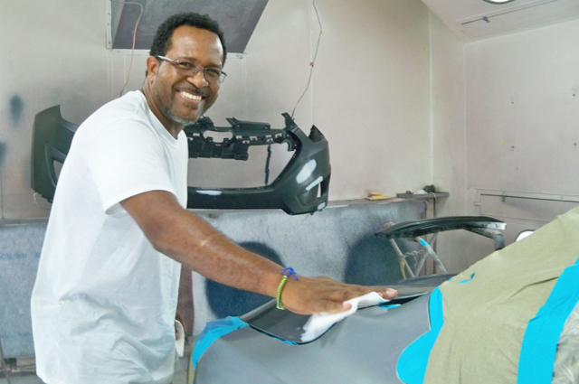 Lincoln Laudat polishes a car at the family-owned 180 Auto Body.