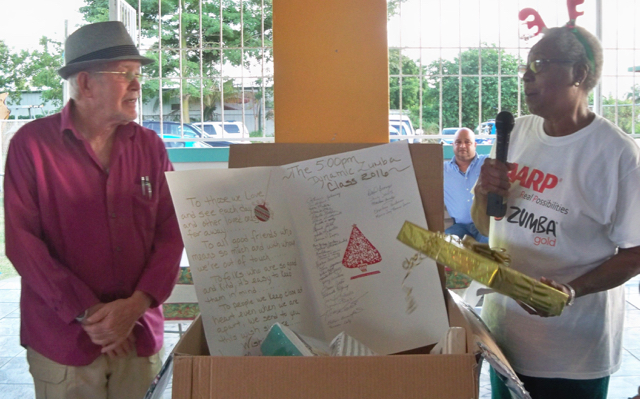 Zumba member Doris Brown presents the program's donation to Luis A. Alicea, Sr.