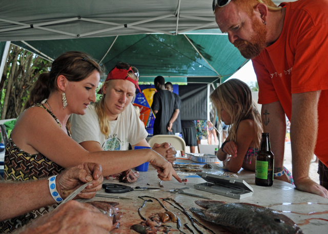 From left, volunteers Kynoch Reale-Munroe and Emily Weston show 2014 Reef Jam visitors the innards of a dissected tilapia, lionfish and squid.