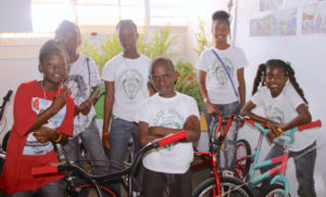 Students from Alexander Henderson Elementary School who participate in the St. Croix Police Athletic League’s youth group pose with the bicycle they refurbished and the plants they grew.