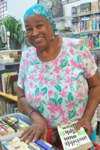 Habiba Evans sorts books at the AWC Flea Market.