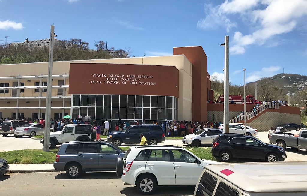 A line of St. Thomians wraps around the Hotel Company Omar Brown Fire Station Saturday. The station was designated a distribution center for relief goods. (James Gardner photo)