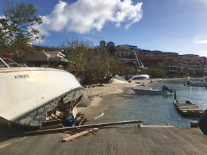 A line of beached and wrecked boats line Cruz Bay's waterfront.