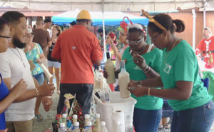 Tawana Nicholas and Jordan Albany pass out samples of coquito at the 2017 Coquit Festival. File photo)