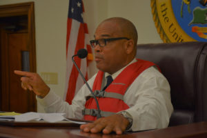 Sen. Brian Smith (D-STT) wears a life vest while chairing Friday's Homeland Security, Justice and Public Safety Committee hearing, in a gibe at VITEMA's late tsunami alert. (Photo by Barry Leerdam, provided by the V.I. Legislature)