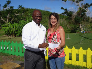 Luis Sylvester presents a donation to Dana Holtz, director at Queen Louise Home in Frederiksted.