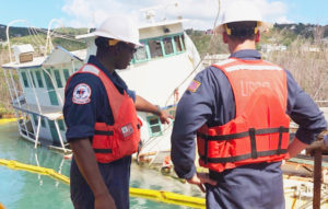 Petty Officer Ken Freeman and Lieutenant Junior Grade Henry Dumphy assess the vessel Leylon Sneed before it was refloated and returned to the owner, Wednesday.  The Leylon Sneed was the last vessel removed from St John under FEMA's ESF - 10 mission. (Coast Guard Photo by Petty Officer Alex Shunda)