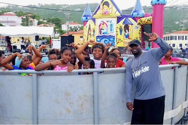 St. Thomas soca star BDJ, right, and a poolful of kids having fun in the water.
