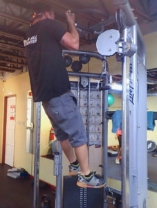 Gordon Holt, co-manager, demonstrates one of the strength machines. 