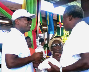 Gov. Albert Bryan chats with We Grow Food, Inc. President Eldritch Thomas on Sunday at the 22nd Rastafari Cultural and Agricultural Fair.
