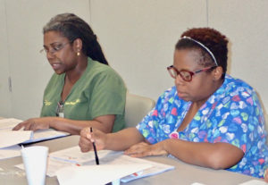 Dr. Olivine Anne Treasure and Faye John-Baptiste, registered nurse, discuss hospital operations Tuesday night. The two were the only board members present for the meeting, leaving the three short of a quorum.