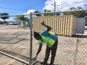 Demar Lewis installs fencing around the Customs lot in Cruz Bay.