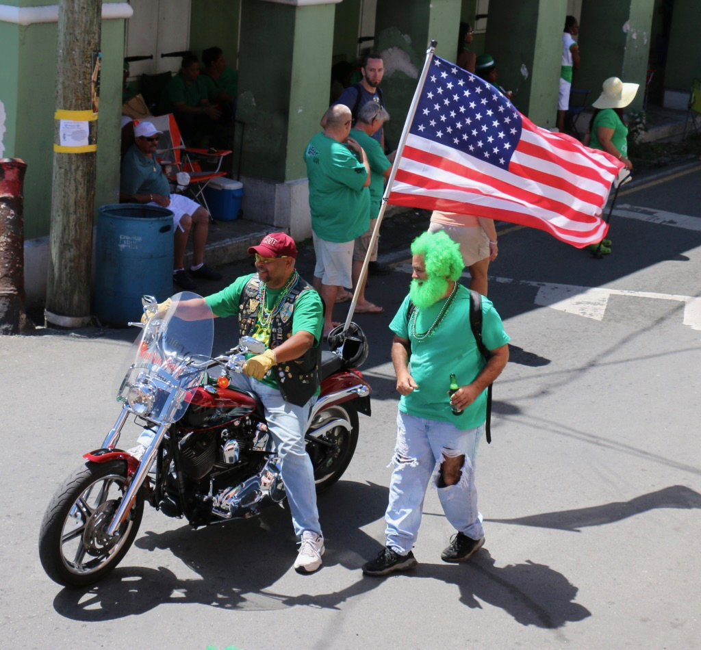 Tony Emmanuel carries the flag early in the parade, the Stars and Stripes snapping in the wind as he rides. (Linda Morland photo)