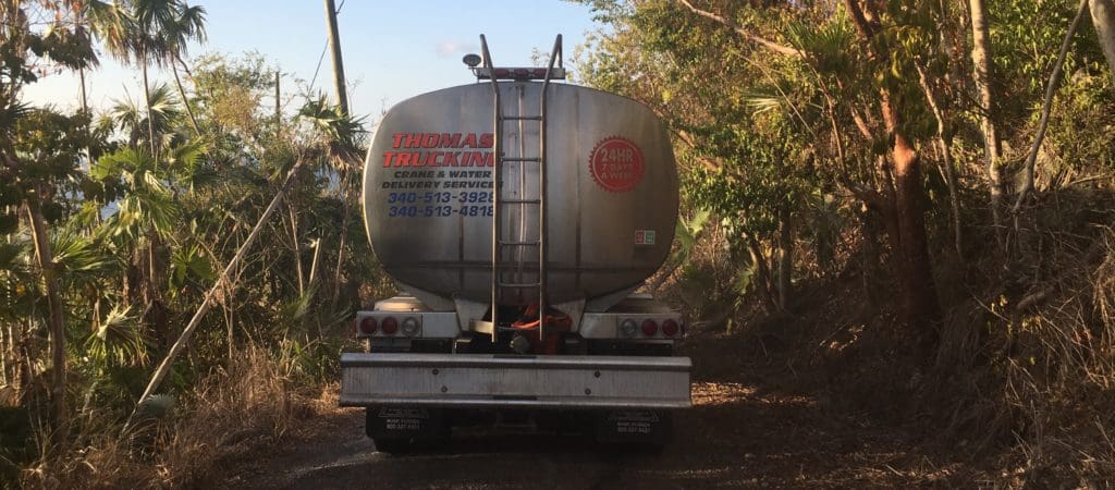 A water truck navigates loosely paved roads while delivering gallons of water to a V.I. resident. (Kelsey Nowakowski photo)