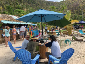 Visitors dine in the shade of an umbrella at Maho Crossroads. (Source photo by Amy Roberts)