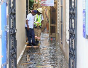 Firefighters navigate the flooded passageways of Royal Dane Mall early Friday morning after the fire. (Source photo by James Gardner)