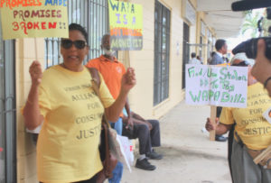 Activists wave signs protesting the proposed WAPA rate increase outside Wednesday's meeting. (Source photo by Bethaney Lee)
