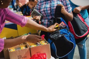 Volunteers stuff supplies into new backpacks Tuesday. (Photo by Samuel Hodges for Home Depot)