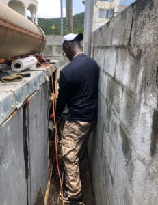 Peter Harris squeezes into a tight spot to wire in the generator. (Source photo Amy Roberts)