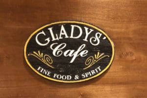 A vintage sign, salvaged from the embers of the devastating blaze the razed the old restaurant, adorns the wall at Gladys’ Cafe. (Source photos by Teddi Davis)