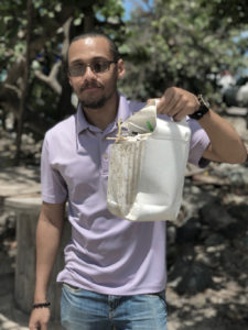 Howard Forbes holds a bucket full of straws collected from Lindberg Beach in a 20-minute period. (Photo provided by Kitty Edwards)