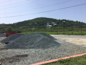 Piles of gravel wait on the lot, ready to be spread for parking. (Source photo by Amy Roberts)