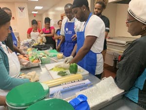 Chef Larry Nibbs of St. Thomas, center, offers kitchen tips and instruction on food prep. (Photo submitted by Government House)