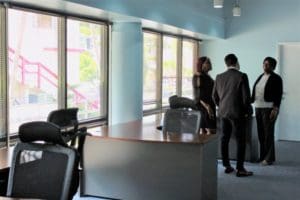 Attendees at the MASA Assist ribbon cutting ceremony chat in the corner of the new office space. (Source photo by Bethaney Lee)