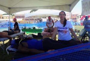 Vicki Hicks, front and Viktoria Reed massage triathletes after they finish the race. (Source photo by Susan Ellis)