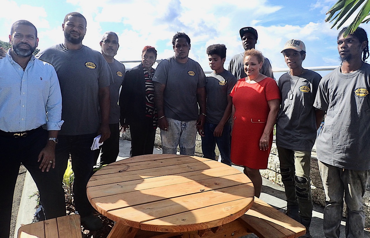 From left, Troy de Chabert Schuster, Derrick Venzen, Eddie Martinez, Alicia Georges, RaySanderson Jr., Dursha Gruhars, Josiah Keels, Jo Ann Jenkins, Christopher Mitchel and Isaiah Moore admire the picnic table designed and built by My Brothers Workshop. (Source photo by Susan Ellis)