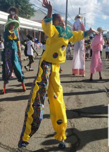 A young moko jumbie gets the feel of the stilts in the parade. (Source photo by Melody Rames)