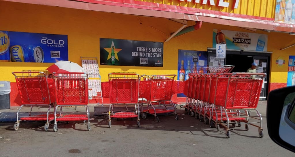 At Pueblo Long Bay, a jumble of carts obscures the store's entrance. (Source photo by S. Pennington)