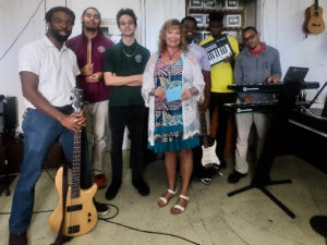 Street Level V.I. founder Priscilla Lynn presents donation to Gifft Hill School on St. John.  From left to right is: music teacher Dennison Blackett, and students Eion Roberts, Christian Foust, Ohsemenard Vales, A.J. Phillips and Ricquan Charlemagne. (Photo provided by Gifft High School)