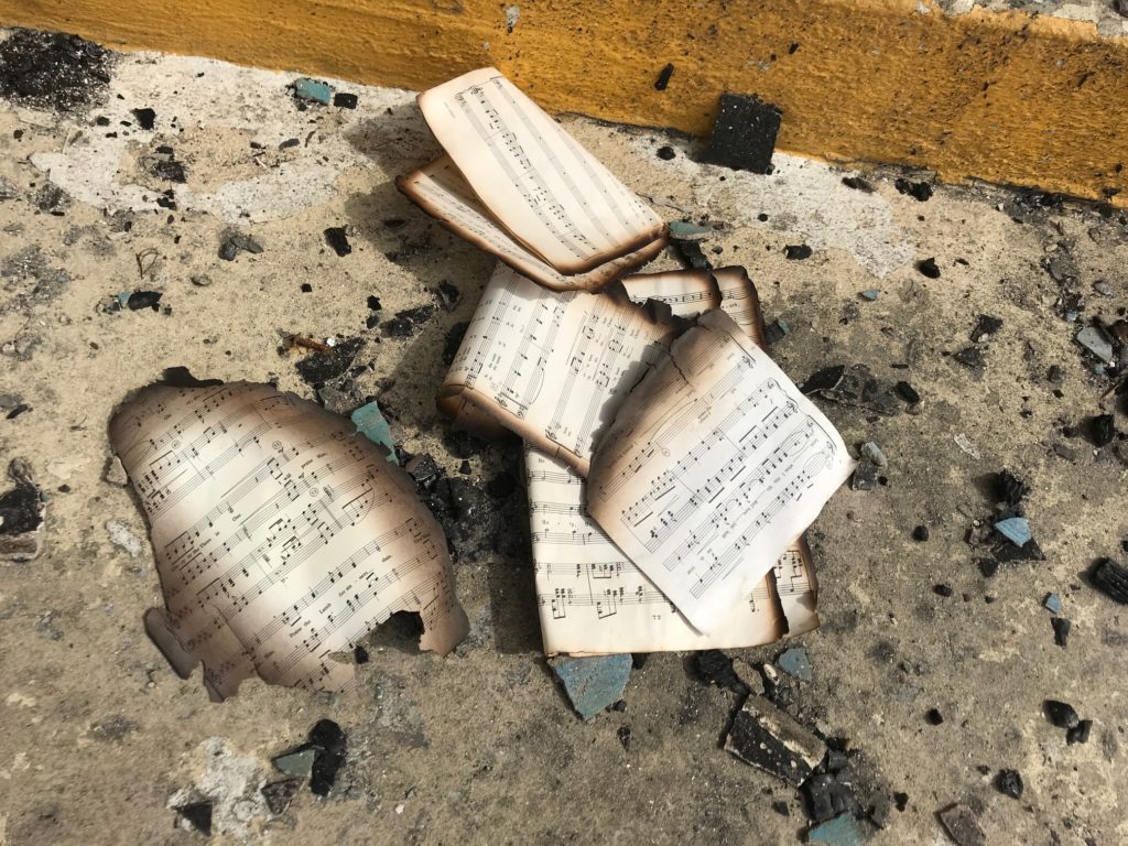 Burned pages of the church's hymnals. (Source photo by Elisa McKay)