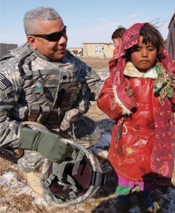 Lt. Col. David C. Canegata III, who served in the Persian Gulf War in Afghanistan, spends a moment with a local girl (Photo provided by Nicole Canegata)