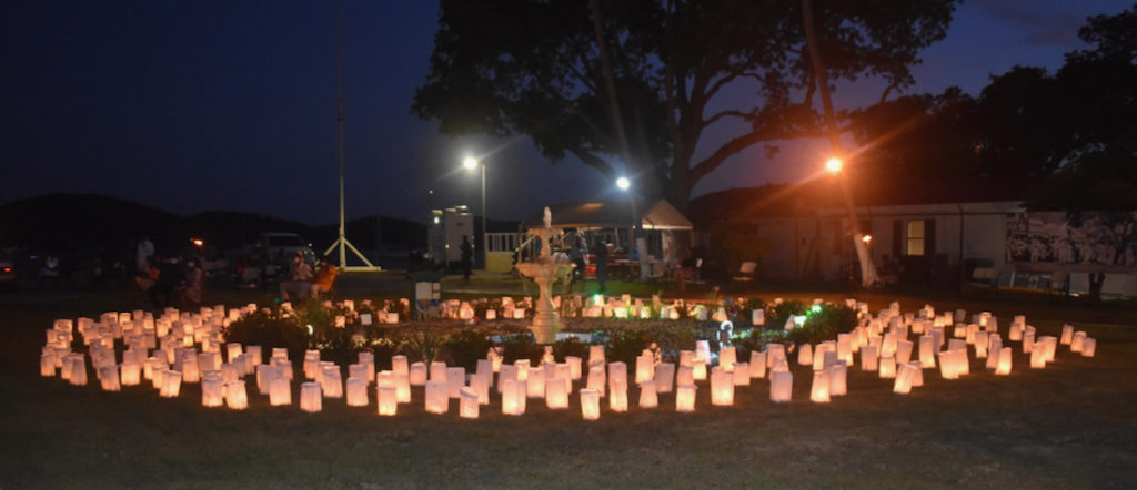 The luminaria – candles in a paper bag weighted with sand – shine on the lawn of Legislative building, memorializing some of those lost to gun violence. (Source photo by Kyle Murphy)