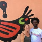 Owners Julie and Shaibu’ pose in front of Sankofa mural. Amy H. Roberts (feature)
