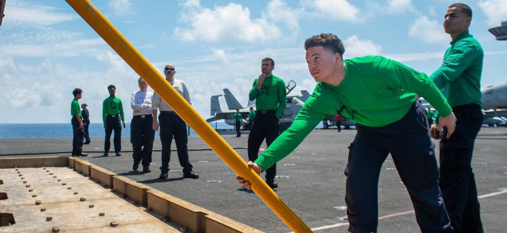 Aviation Boatswain's Mate (Equipment) Airman Oliver Tejada, from Saint Croix, places a stanchion for a jet blast deflector on the flight deck of USS Harry S. Truman (CVN 75) on June 9 in the Ionian Sea.