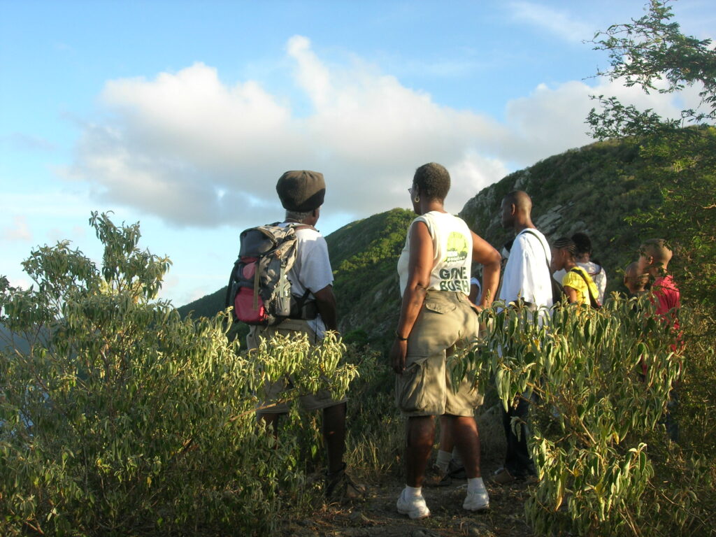 Olasee Davis, left, leads hikers on a trek of Maroon Ridge to overlook the Maroon Hole. Enslaved people jumped from these cliffs and deep valleys in a bid for freedom, according to oral history. (Photo courtesy of Olasee Davis)