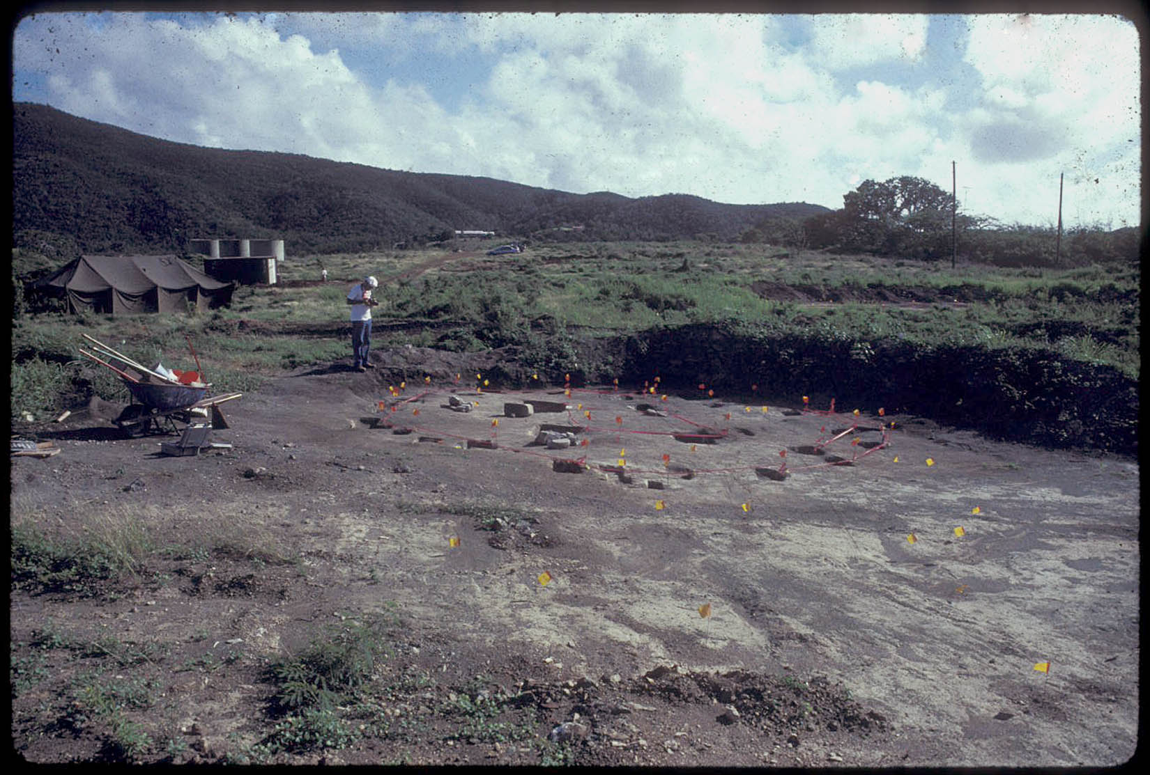 A researcher photographs an outline of a structure at Tutu. (Photo by Emily Lundberg)